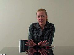 Cute and shy looking blonde babe in dark shirt gives an interview at the desk before her first porn audition and showing all of her talents to the cam
