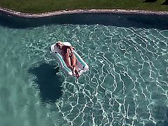 Turned on young blonde babe Evelyn with natural boobies and tight ass get naked and fingers her tight honey pot to orgasm while teasing in backyard in the pool.