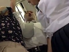 This naughty Japanese schoolgirl is caught between two guys in a crowded bus. She rubs her ass against one guy's cock and than she gives him a handjob.