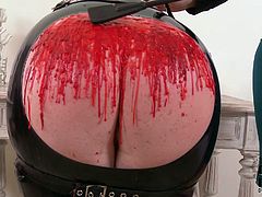 Hefty BBW chick in wearing leather mask bends over the table and gets her ass caned by sultry redhead mistress. Then she pours hot wax on that big ass.