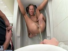 Spoiled skinny brunette hussy gets lured by pervert dude. He forces her to get inside the bathtub and lies on her back with legs pulled towards her head while he directs powerful stream of hot water on her ruined pussy.