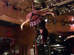 Sexy brunette pole dancer takes off her clothes on the stage