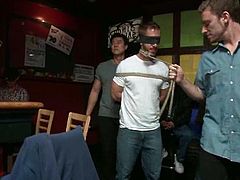 This guy gets undressed and tied up by some dudes in a bar. After that he sucks their dicks and gets his asshole stretched to the limit.