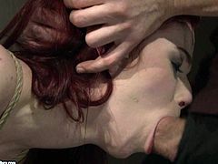 Hussy roped red haired babe moans in pain while horny stud tortures her. He ties her up and make her suck his cock. He penetrates deep her throat and reaches her tonsils.