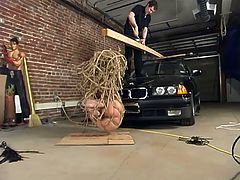 She takes that dude to the garage and asks him to torture her. All the tools are ready and babe is being tied up and abused pretty hard.