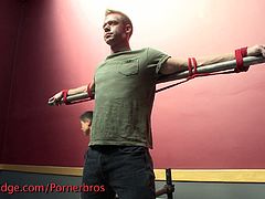 This blonde stud has his nipples and cock torture while he's tied up to the bed and to metal bars.