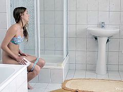 This teen sits on the toilet and pees. Then, she washes herself with a little water and sits without panties. She starts rubbing her hairless pussy and enjoys.