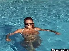 Get excited watching this blonde lady, with giant natural boobs wearing a white bikini, while she plays with a basketball and swims in a solo model clip.
