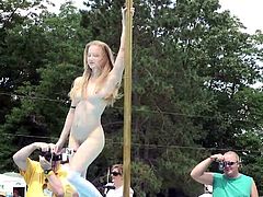 Watch this sexy blonde dancing on a pole in this hot party outdoors as you can feel a boner growing in between your legs.