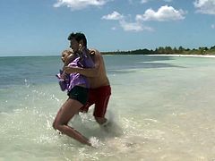 These two splash around in the water then he strips off her bottoms and fucks her hard right there in the sand on the public beach.