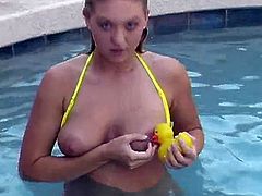 A curvaceous blonde girl in a yellow bikini swims in a pool. After some time Alison takes off a bikini and also licks her nipples.