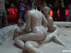 Take a look at this hot scene where these sexy ladies battle in a mud pool as they end up having a threesome with a guy joining the fun.