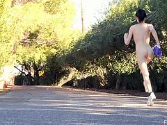 A brunette girl jogs around a neighborhood. It is very hot out there, so she takes off her clothes and jogs being naked. Then she sits down on a bench and fingers herself.