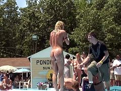 A petite blonde chick is having fun on the poolside in public. She strips and soaps her nice body, then lies down on the floor and flashes her cunt for the camera.