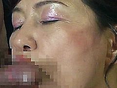 Lovely Japanese MILF with a pair of large soft boobs has her arms bound behind her back. She kneels in front of one horny dude and slurps his erect cock.