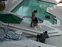 Black dude films to black chicks going at it by the pool and then joins them for a steamy ebony threesome outdoors