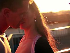 Sandy Ambrosia and her lover are somewhere outdoors. They kiss each other passionately and they hug each other as well. The sun is about to come down, so it is romantic.