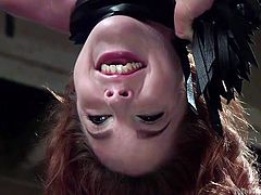 Someone has to train these sluts how to please a man, and it's Amarna's turn now. The beautiful redheaded slut is upside down, bound with chains by her executor, while sucking another guy's dick, taking every inch in her oral hole. She does quite well, as you can see in the video below.