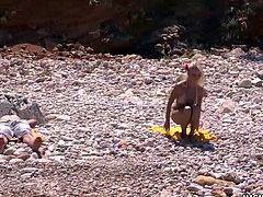 Sensual blonde babe gets pleasured on a remote beach.