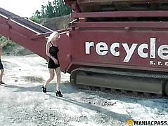 Blonde pissing behind the tractor