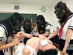 Japanese schoolgirls wearing gas masks surround a supine male classmate covered in bandages and intimately examine his erection in this bizarro world CFNM school fantasy with English subtitles