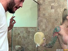 A hot blonde-haired bitch lures her passionate partner in the bathroom, where she is taking a soapy shower. Watch the excited man squeezing her marvelous boobs. Don't miss the inciting tit job, performed by the sexy tattooed milf!