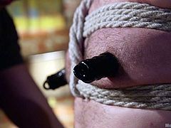 Owen is tied up and gagged, so his cries of pain or pleasure won't disturb the neighbors. His dominant has a rope around his balls, and he tugs his cock, even sucking for a little bit. Owen now gets a dildo in his asshole, while all this is going on.