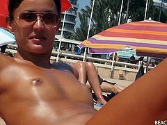 Small tits girl with a great tan is topless at the beach