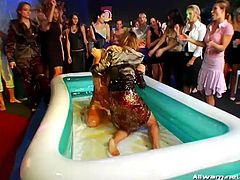 Ladies coated in gooey oil wrestle and play in a pool