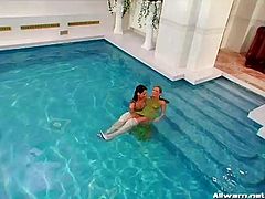 Playful lesbian couple take a full clothed swim in the pool