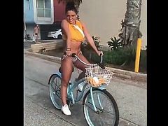 Jade Chynoweth riding a bicicle in bikini bottoms