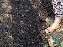 lady takes off sandals.working barefoot in the garden