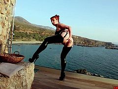 Mature redhead Red XXX teases outside on the balcony next to the ocean in her sexy latex lingerie before stuffing her tight fuck hole with a dildo until she orgasms